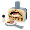 The Wooden Make Me A Pizza Set is designed for pretend play, with accessories including a pizza paddle, a pizza with assorted toppings, and a condiment shaker, all displayed on a white background.