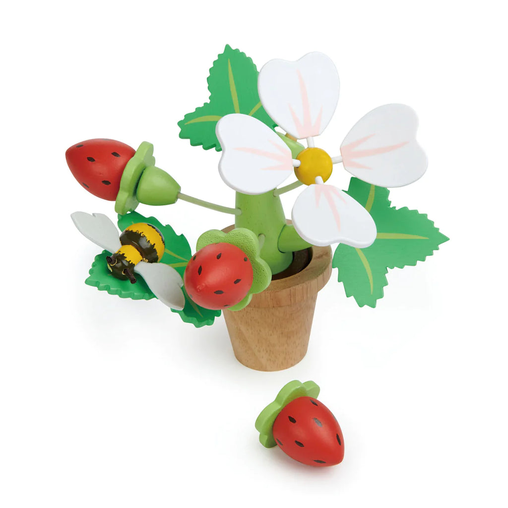 A wooden toy depicting a Strawberry Flower Pot with white flowers, green leaves, and red ladybugs, against a white background. A magnetic bumblebee and an additional ladybug are on one of