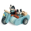 The Badger Picnic Motorbike Ride features a wooden motorbike with sidecar, two black and white badger figures, a suitcase, and a small bag in soft blue and tan—ideal for imaginative countryside adventures.