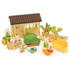Bunny’s Carrot Patch features a charming wooden house, three bunny rabbit figures, a cart, crates, leafy vegetables, a sofa, tableware, and a green watering can—all beautifully arranged to inspire imaginative play in a whimsical vegetable garden farm scene.
