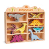 A wooden shelf labeled "Dinosaurs Set" filled with colorful, rubberwood dinosaur figures in various shapes and sizes.