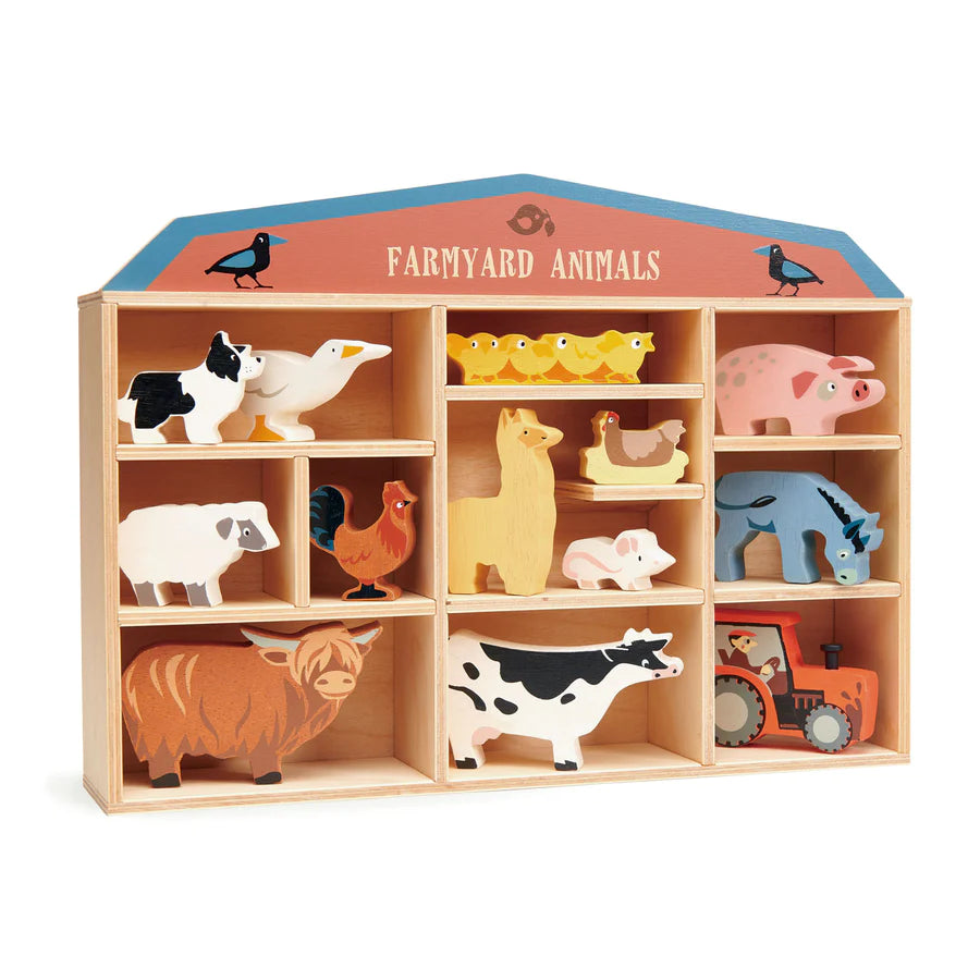A wooden display shelf shaped like a barn, labeled "farmyard animals," containing various colorful wooden animal figures such as a cow, pig, chicken, and more. This plastic-free toy is made from Farmyard Animals Set.