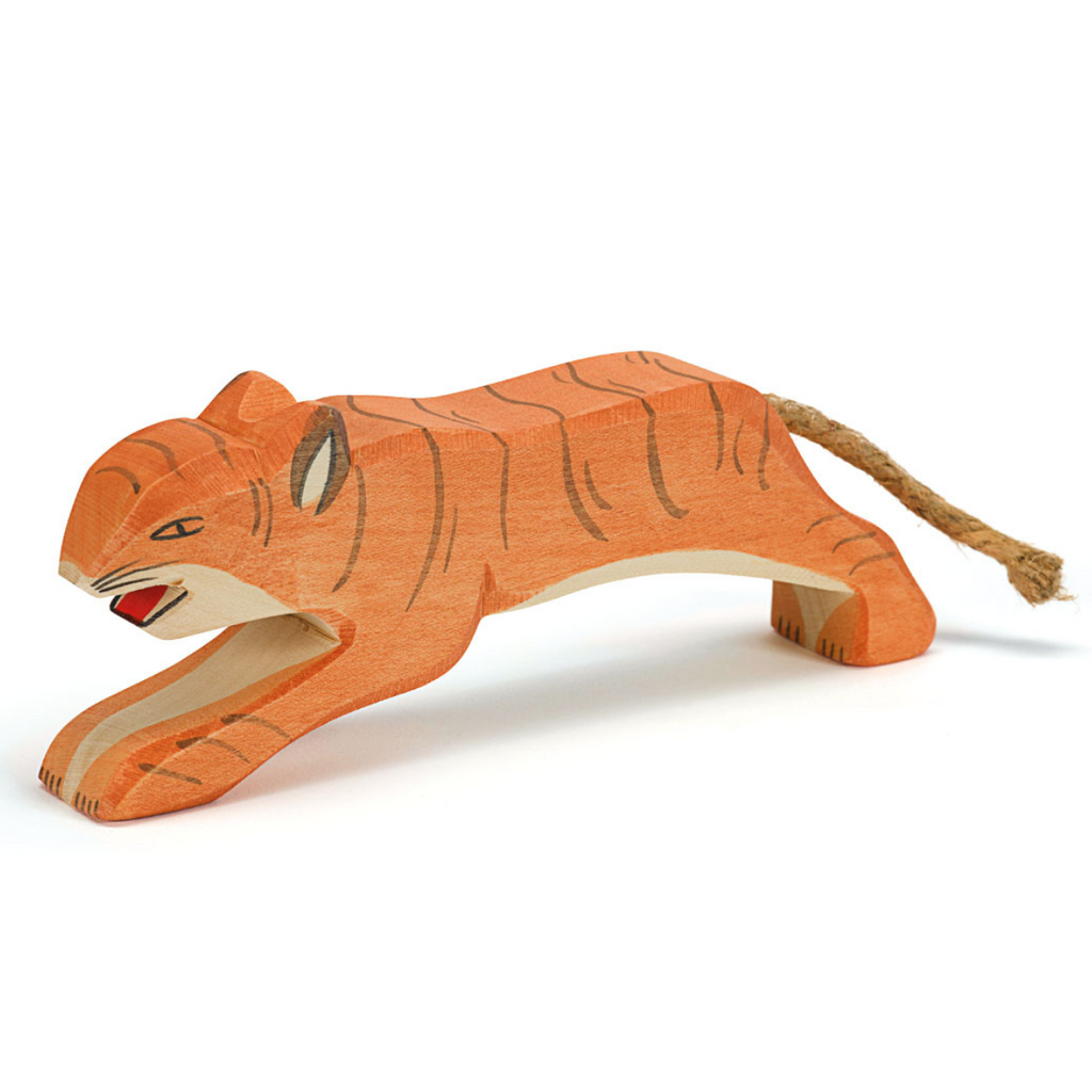 A wooden tiger figurine, painted in orange with black stripes, is depicted in a crouching position. This Ostheimer Jumping Tiger features a simplistic design with minimal details and has a rope tail attached, perfect for imaginative play.