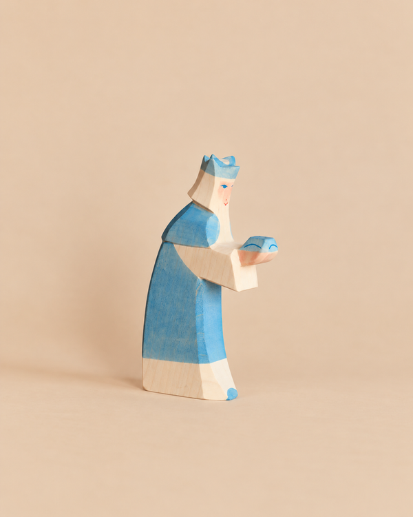 Ostheimer Blue King With Crown, a handcrafted wooden toy of a king in a blue crown and robe holding a small blue gift for imaginative play.