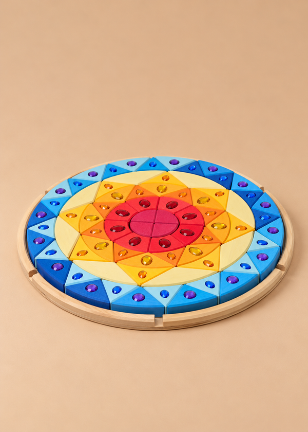 The Grimm’s Sparkling Mandala Sun Creative Puzzle is a circular wooden puzzle with a sunburst pattern of colorful triangular blocks, each featuring a faceted jewel accent, designed to support fine motor skills.