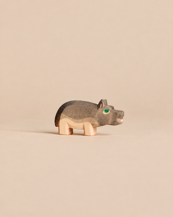 Handcrafted Ostheimer Hippopotamus - Small wooden figurine with a grey back and green eye.