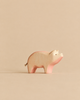 A Handmade Holzwald Pig minimalist wooden figurine featuring pink-tinted accents, crafted as a sustainable toy.