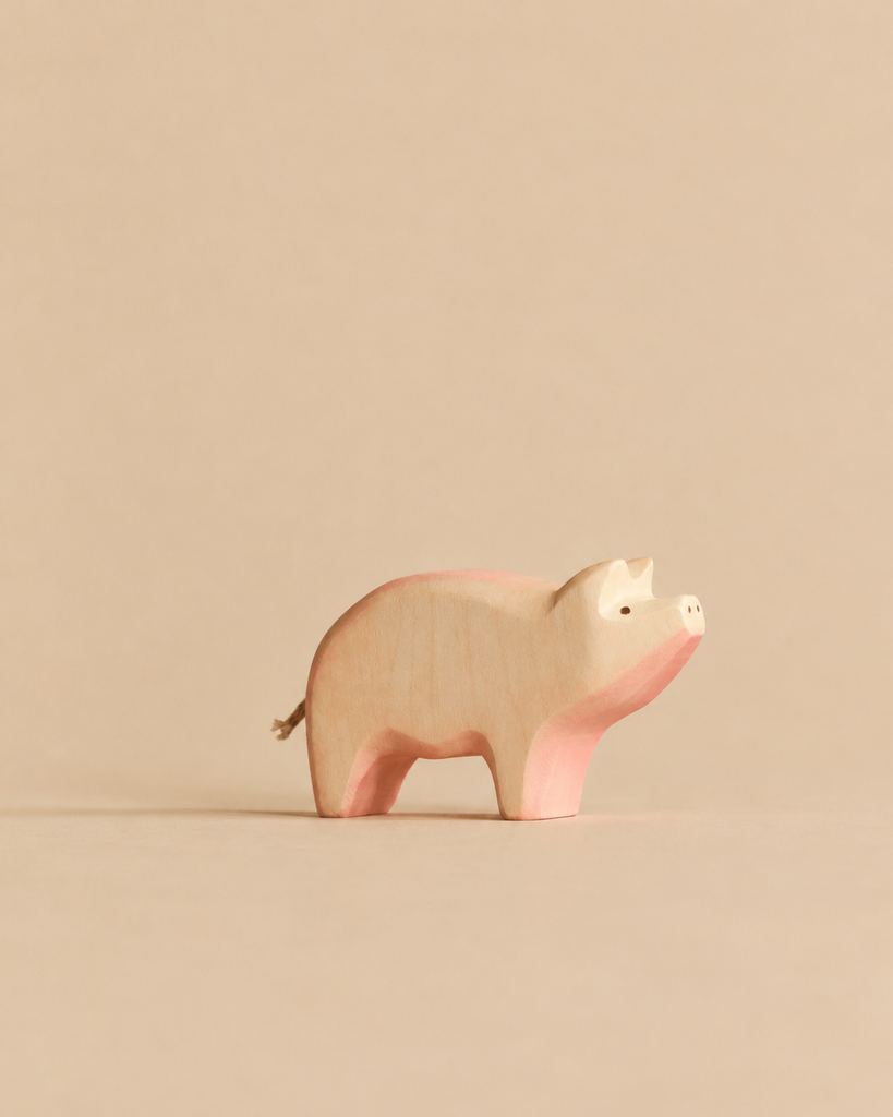 A Handmade Holzwald Pig minimalist wooden figurine featuring pink-tinted accents, crafted as a sustainable toy.