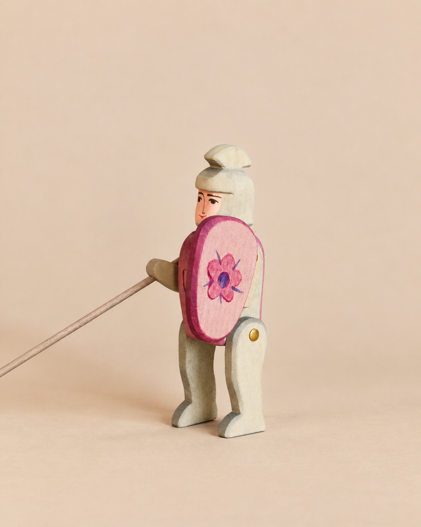 Ostheimer Red Knight - Riding handcrafted from wood, wearing a helmet and holding a round shield with a flower design and a long lance, perfect for imaginative play.
