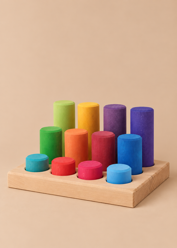 Grimm’s Stacking Game Small Rainbow Rollers featuring ten colorful, cylindrical blocks of varying heights on a wooden base, arranged in a grid for color sorting and motor skills.