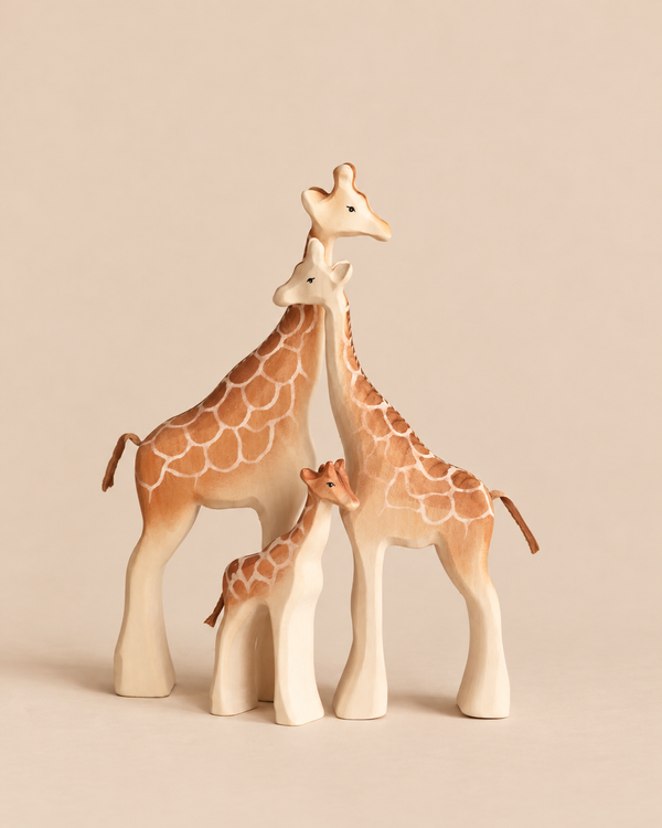 Bumbu Handmade Wooden Giraffe Family Set consisting of three hand-carved organic wood giraffe figures of varying sizes standing together.