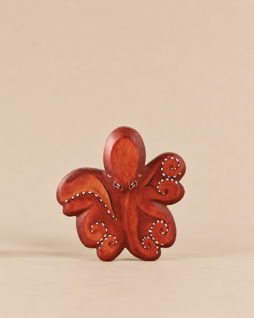 A Handmade Holzwald Octopus carved wooden figure with painted white dot detailing on its tentacles.