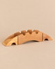 The Ostheimer Bridge With 2 Ramps is a handcrafted wooden toy bridge made of three interlocking pieces with a crenellated top edge and two sloping ramps, perfect for imaginative play.