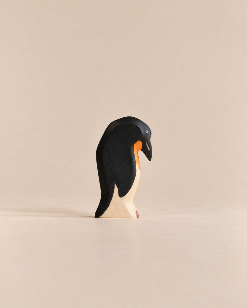 Handmade Holzwald Penguin, Head Down, a small wooden toy figurine crafted from sustainable materials shown with its head bowed downward.