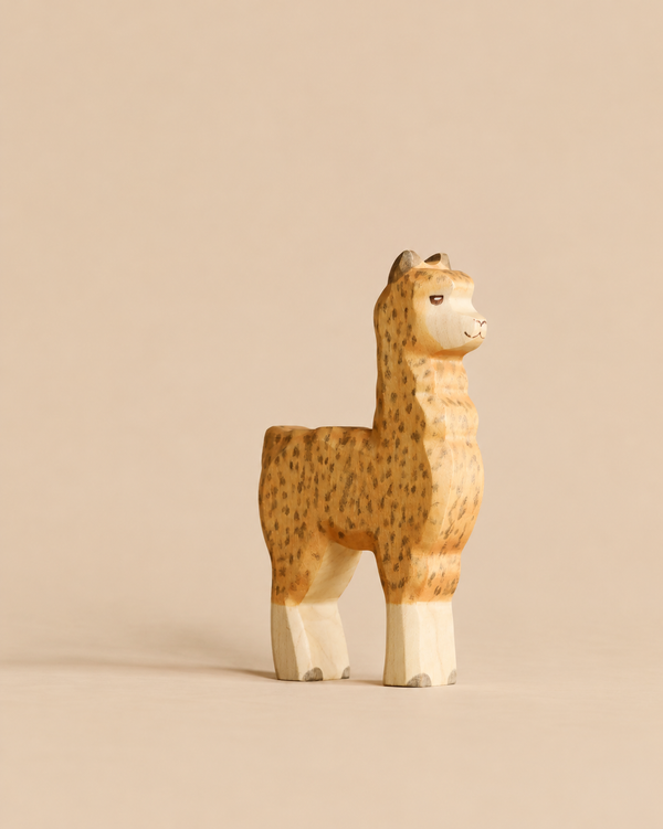 A Handmade Holzwald Alpaca wooden figurine of a spotted alpaca.
