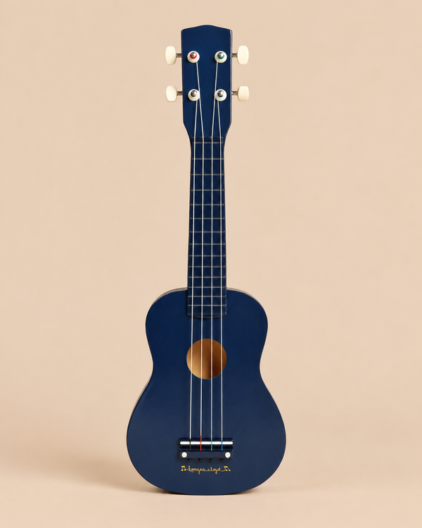 Konges Sloejd Wooden Ukulele - Midnight in dark blue FSC certified wood with four strings and a gold circular sound hole.