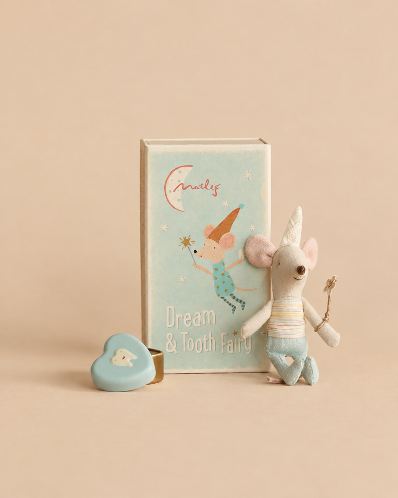 A Maileg Tooth Fairy Mouse, Little Brother wearing a pointed hat and holding a wand, standing next to an illustrated matchbox and a small blue heart-shaped container.