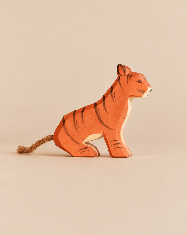 Ostheimer Sitting Tiger, a hand-carved wooden figurine in a sitting position with a rope tail, perfect for imaginative play.