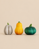 Bumbu Handmade Wooden Pumpkin Patch Set featuring three decorative pumpkins in grey, yellow, and green, each with a small green stem.
