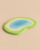 An Ostheimer Pond handcrafted wooden toy piece, flat and kidney-shaped, with a painted blue water center surrounded by a green grassy border.
