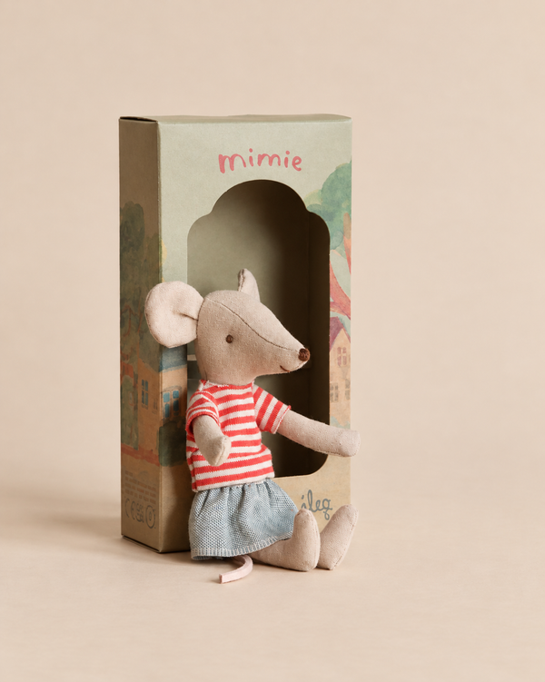 A Maileg Mouse With Striped Shirt - Big Sister in a red striped t-shirt and blue skirt sits in front of its cardboard decoration box.