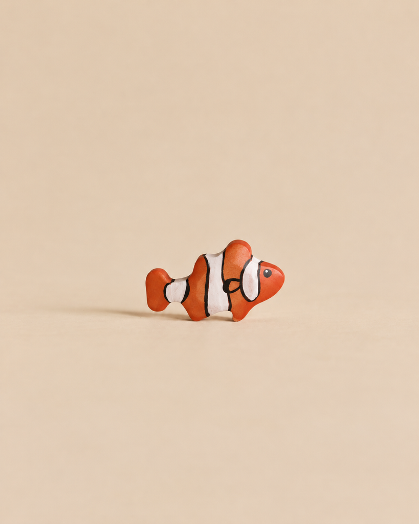 Small handmade Holzwald Clownfish figurine with orange, white, and black stripes.