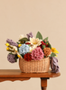 A Basket of Handmade Felt Flowers - Final Sale filled with a variety of colorful handmade felt flowers arranged as an eco-friendly floral display on a wooden table.