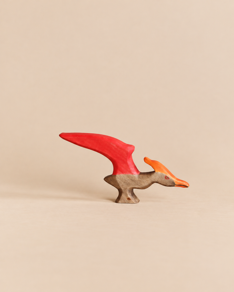 Handmade Holzwald Dinosaur - Pteranodon toy for imaginative play, featuring a red wing, orange crest, and natural wood body.