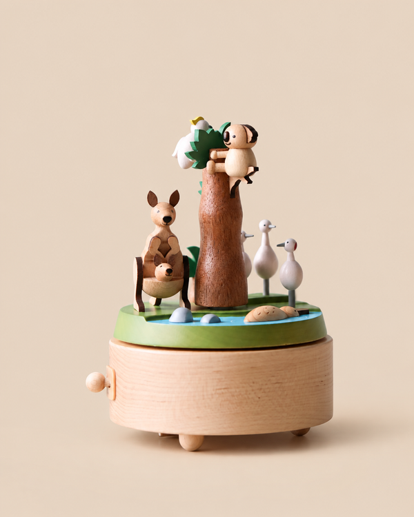 A Wooden Australian Safari Park Music Box featuring a kangaroo with a joey, a koala on a tree, and three birds around a small pond.