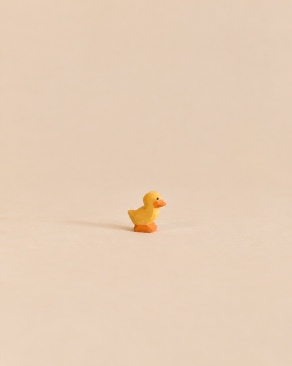 Small, handcrafted Ostheimer Duckling figurine with a yellow body and orange feet, perfect for imaginative play.