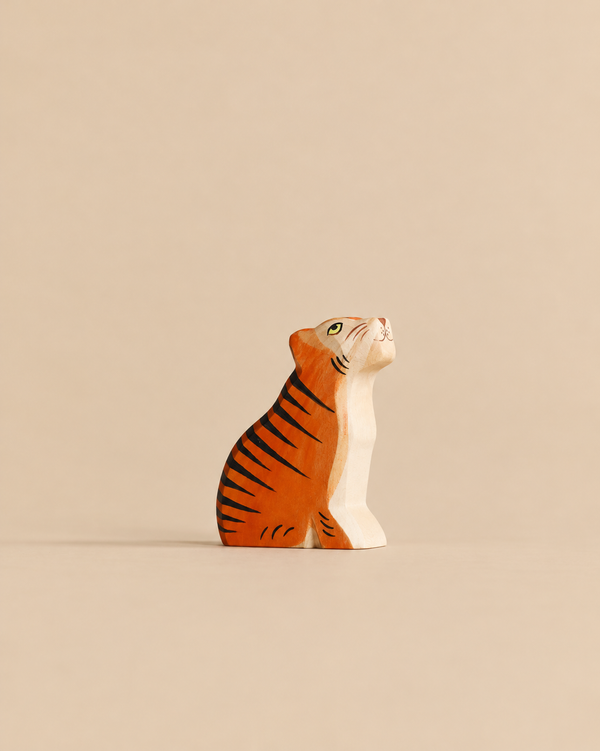 Handmade Holzwald Sitting Tiger figurine in a sitting pose, painted orange with black stripes.