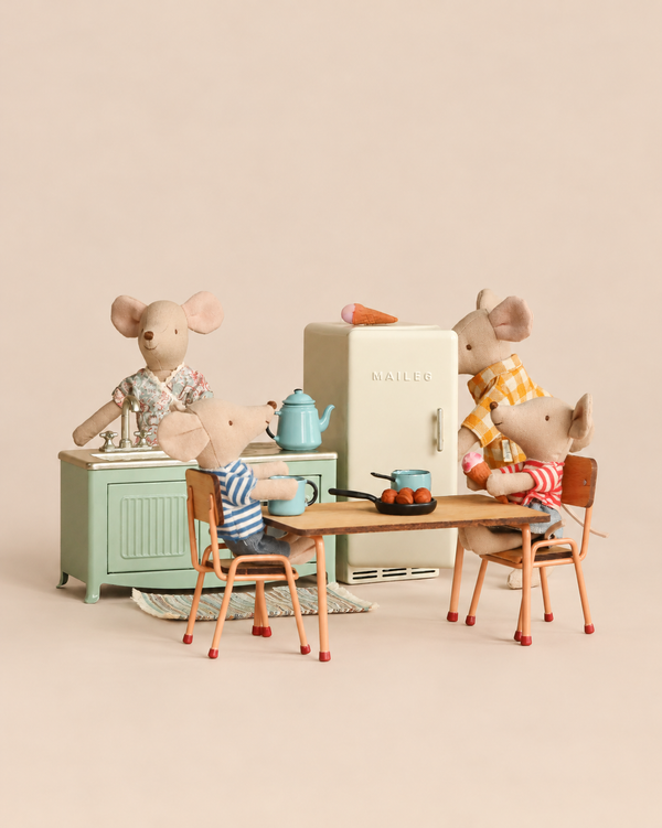 A Maileg Kitchen Set with Family featuring four mice in a miniature kitchen with a refrigerator, sink, table, and chairs.