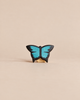 Handmade Holzwald Butterfly, a small, sustainable wooden figurine with black wings featuring bright blue details for imaginative play.