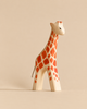 Handmade Holzwald Giraffe - Large, a sustainable wooden giraffe toy with painted orange spots and a rope tail.