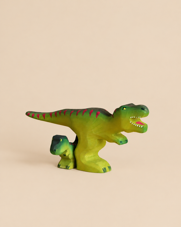 A Bumbu Handmade Wooden T-Rex Dinosaur Set featuring two green wooden T-Rex figures, one large and one small, standing together.