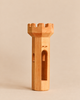 The Ostheimer Round Tower is a handcrafted wooden toy tower featuring a crenelated top, a central arched doorway, and small window openings for imaginative play.