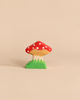Holztiger Toadstool handcrafted wood toy with a red spotted cap and a green grassy base.