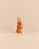 A small Ostheimer Rabbit - Ears Up wooden figurine shown in profile with upright ears.