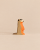 Handmade Holzwald Meerkat wooden figurine in profile, colored in shades of brown and orange.
