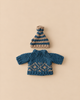 A blue and tan striped knit hat sits above a blue sweater featuring a tan Scandinavian geometric pattern for the Maileg Extra Clothing: Knitted Sweater And Hat for Dad Mouse.