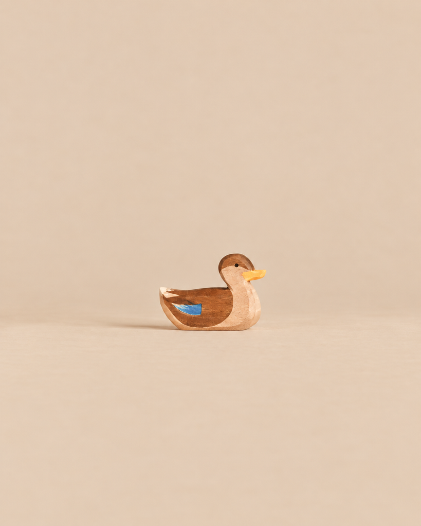 Ostheimer Duck, Swimming, a small handcrafted wooden figurine with brown coloring and a bright blue wing detail.