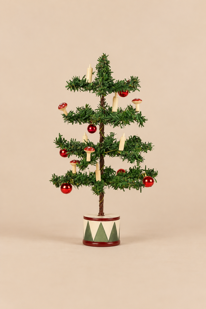 A small Maileg Christmas Mice Set tree in a decorated base, adorned with miniature red ornaments, wooden candle figures, and toadstool decorations.