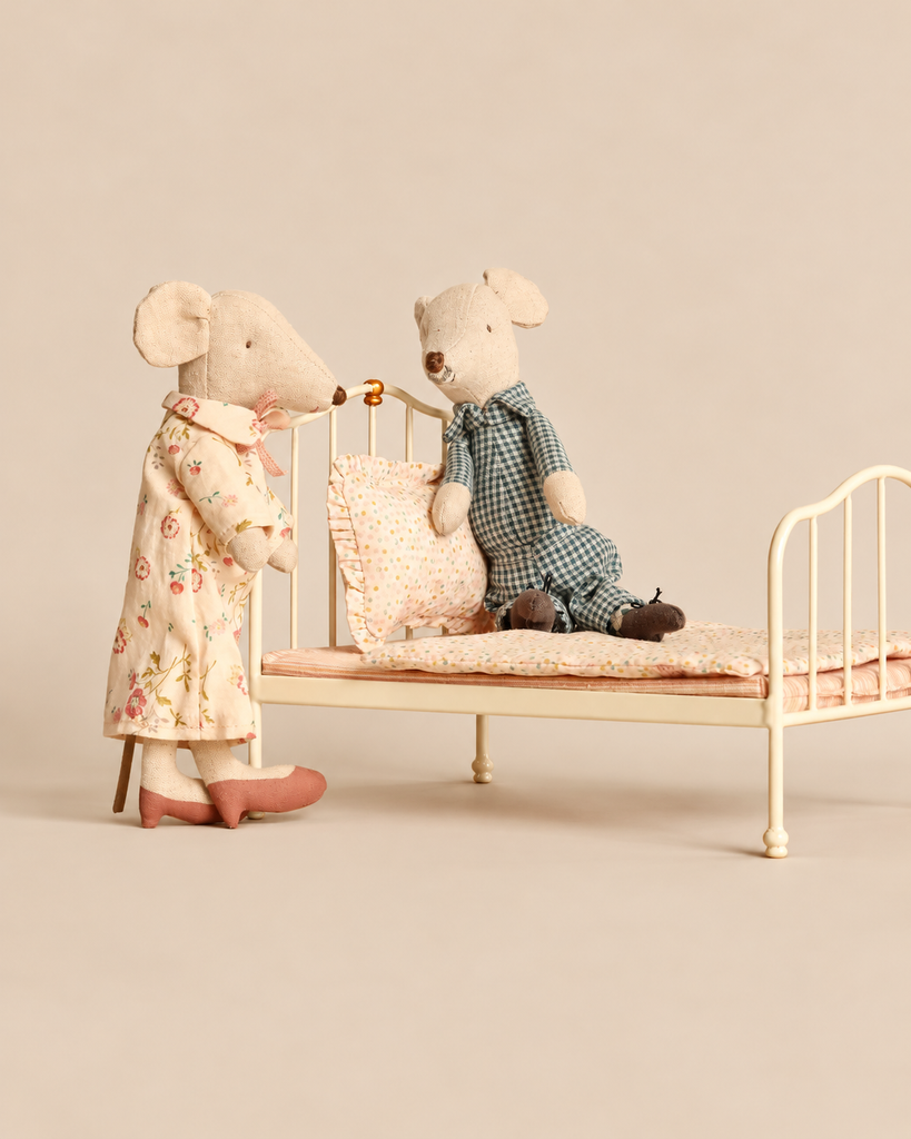 A Maileg Bedroom Set with Grandma & Grandpa featuring a standing mouse and a sitting mouse on a miniature metal vintage bed frame with a mattress and pillow.