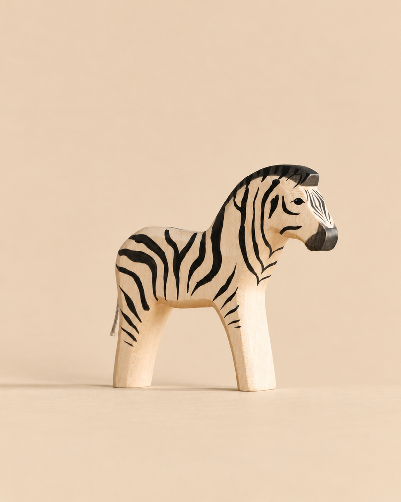 A handmade wooden zebra toy from the Handmade Holzwald Safari Animals Set with black painted stripes.