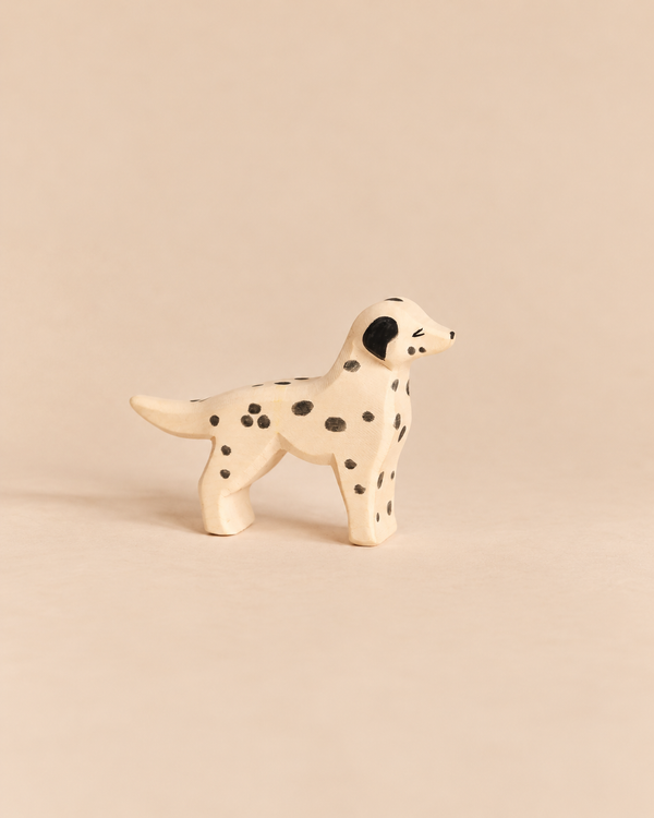 An Ostheimer Dog - Dalmatian handcrafted wooden dog toy with black spots and a black ear.