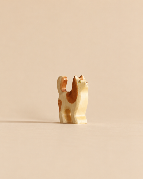 Handmade Holzwald Cat: a small wooden figurine with brown spots and green eyes, crafted as a sustainable toy.