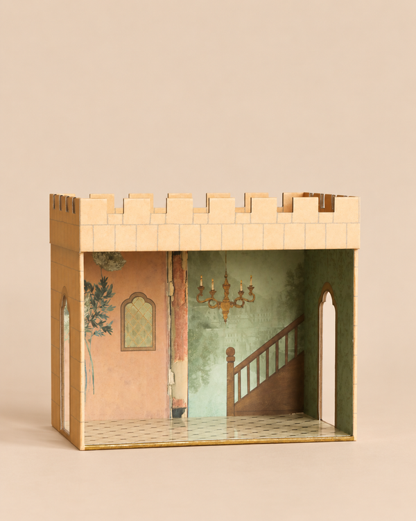 A cardboard Maileg Castle Hall shaped like a palace, featuring painted interior walls with a staircase and a chandelier.