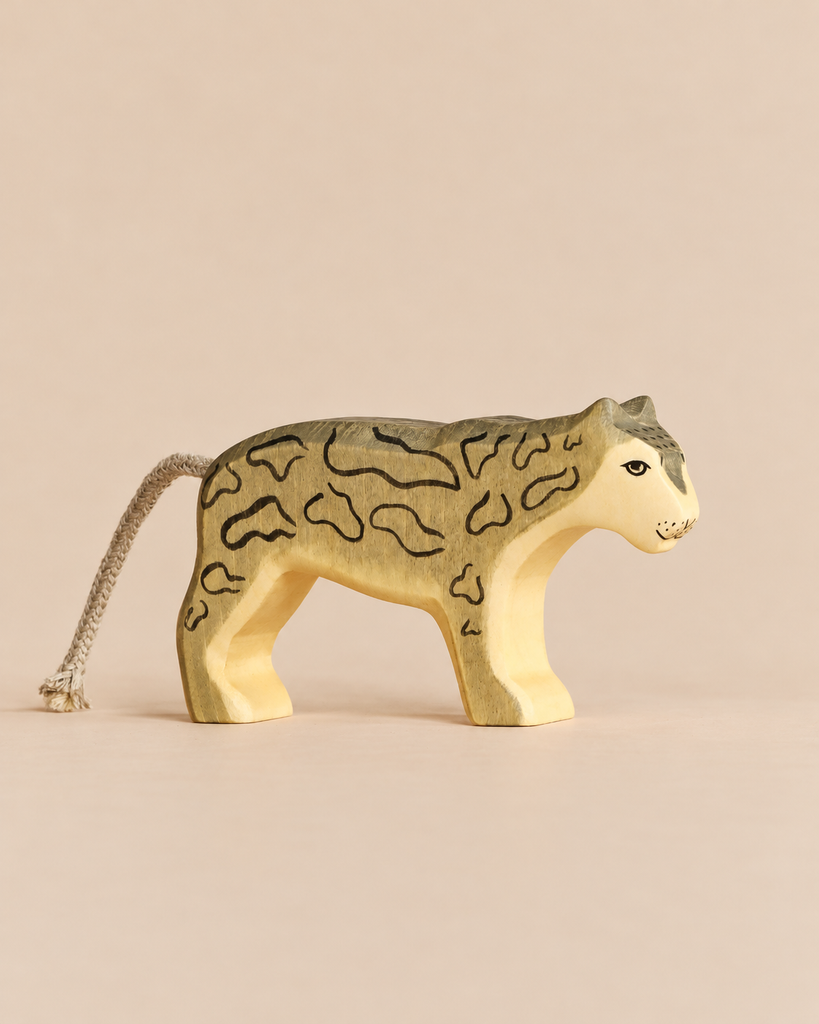 Hand-painted Handmade Holzwald Snow Leopard wooden toy figurine with a rope tail and detailed markings.