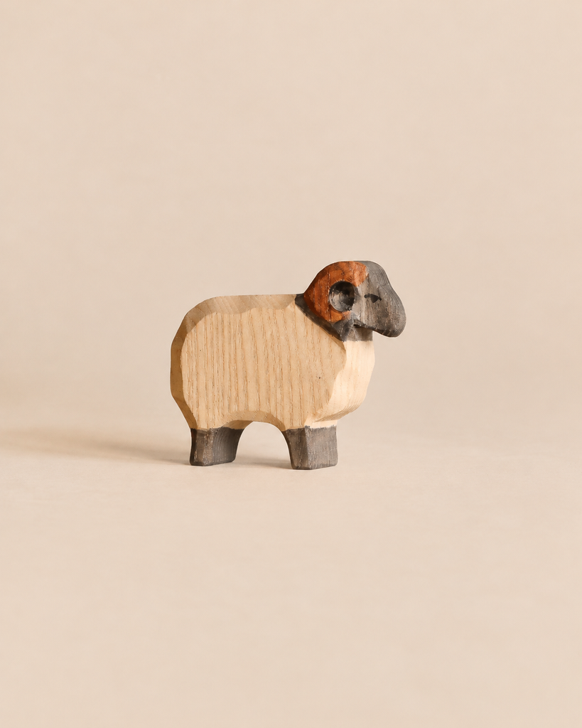 Ostheimer Moorland Ram handcrafted wooden toy featuring a natural wood body, dark face, and curved horns.