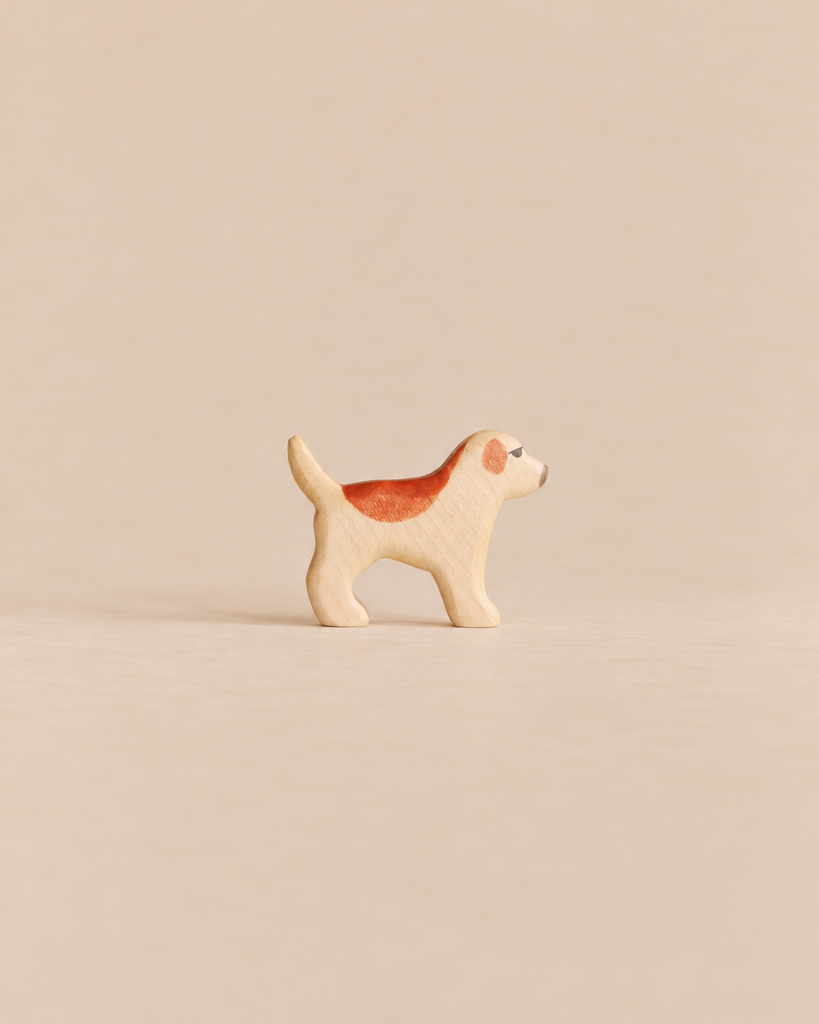 Handmade Holzwald Dog - Golden Retriever Puppy, a small, sustainable wooden toy figure of a standing dog with a brown patch on its back and eye.